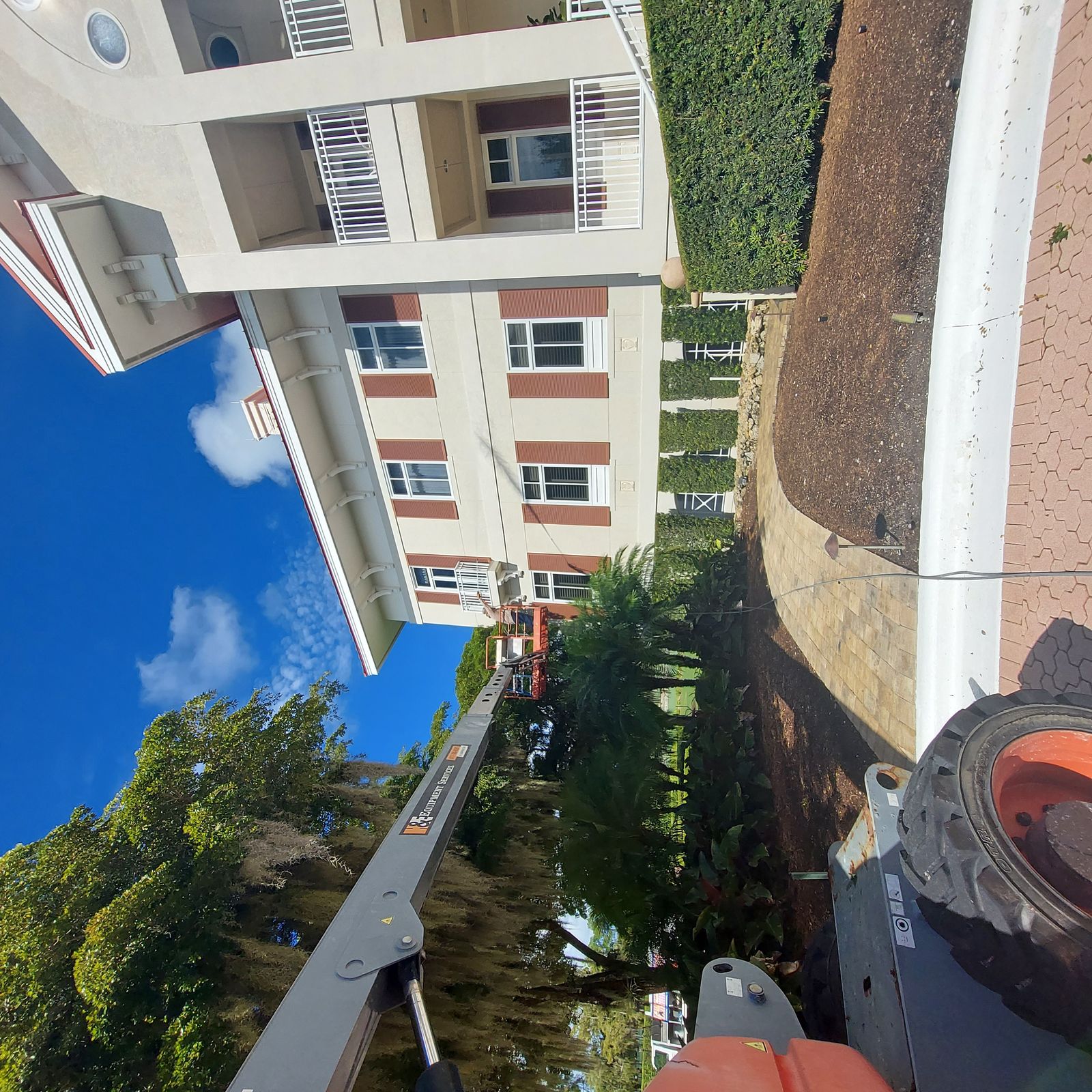 Boom lift pressure washing multi-story building — SW Florida